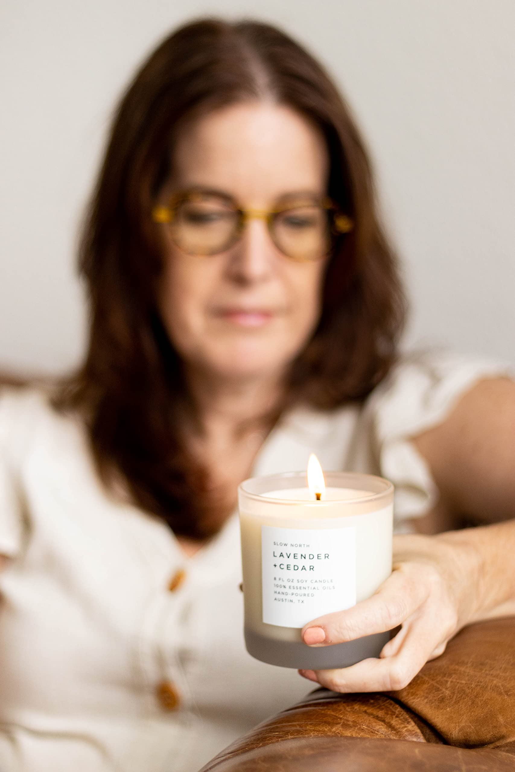Candle burning beside cozy home decor in a living space