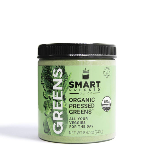 SMART Pressed Organic Greens powder bottle on kitchen counter, ideal daily energy boost.