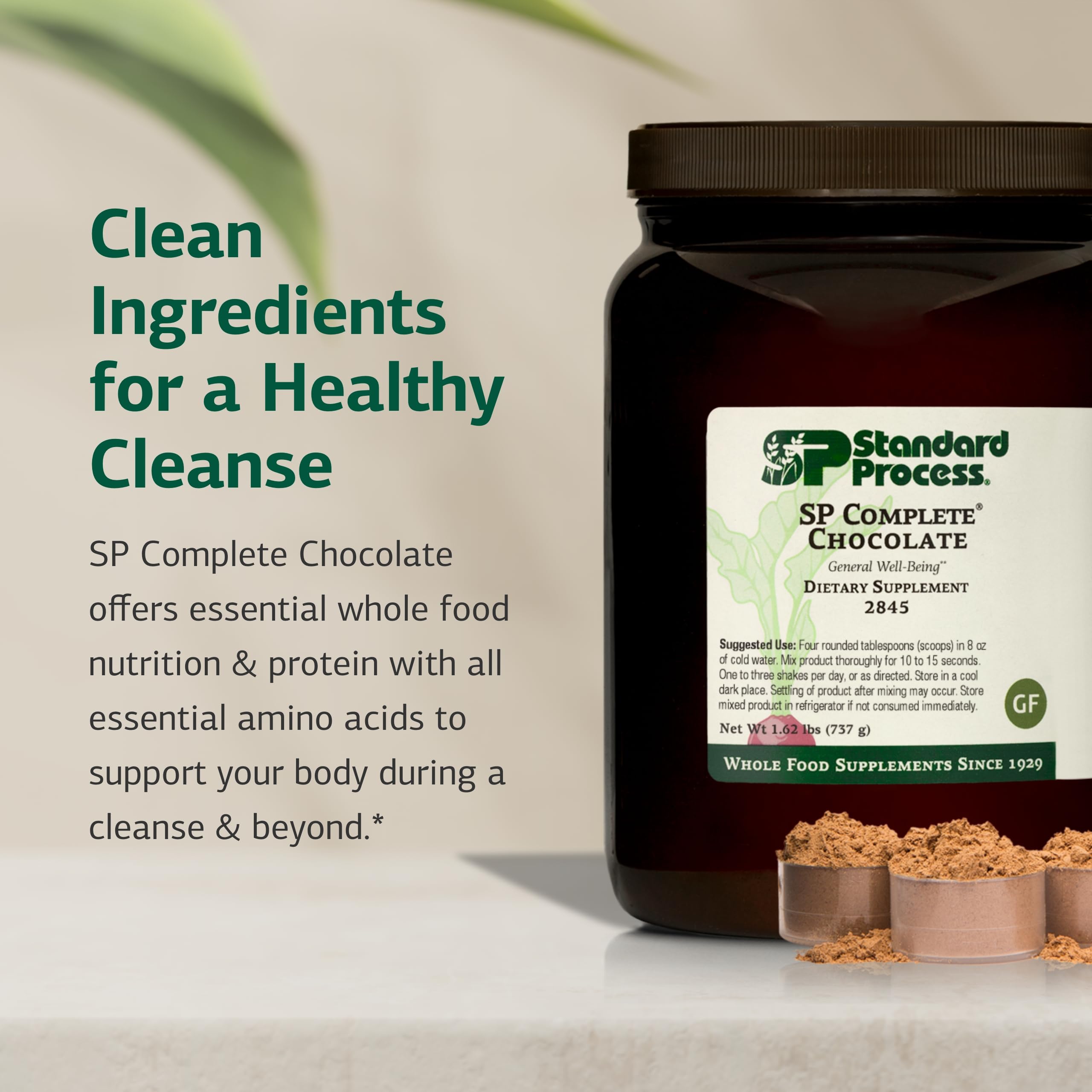 Standard Process SP Complete canister beside a glass of prepared shake for daily nutrition.