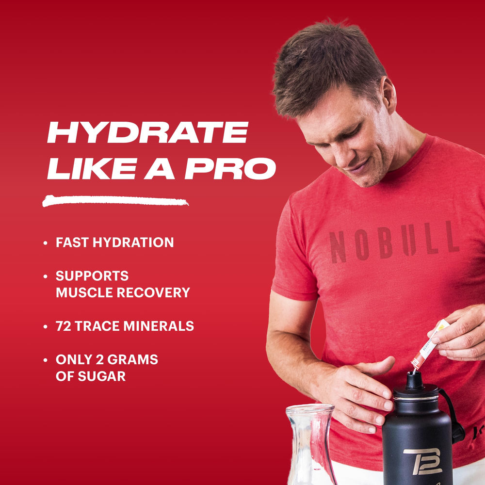 TB12 Electrolytes Fruit Punch powder stirred into a bottle.