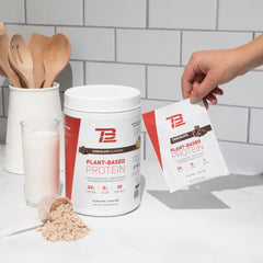 TB12 non-GMO label beside chocolate powder on clean packaging.
