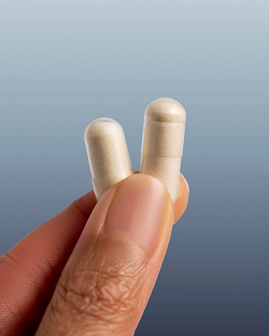 The Nue Co Vitamin C capsules in hand for daily energy support.