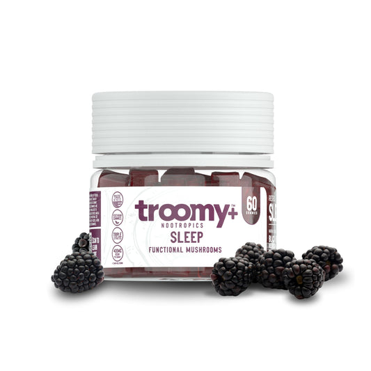 Troomy Sleep Gummies bottle on nightstand with black raspberry flavor