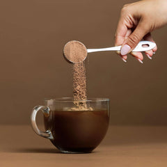 Spoon resting on opened tub for daily chocolate collagen routine