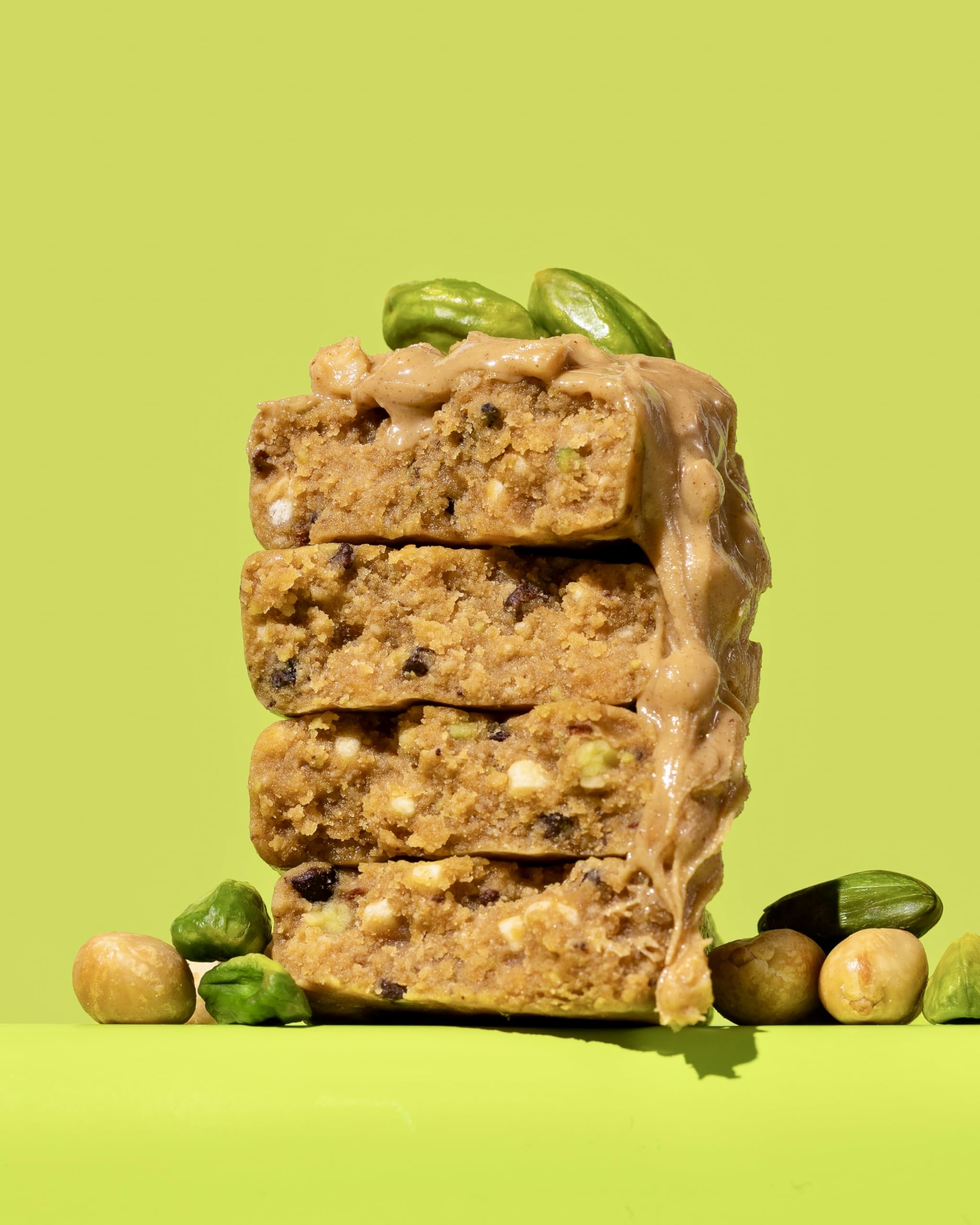 Close-up texture of peanut butter and pistachio crunch, satisfying and clean.