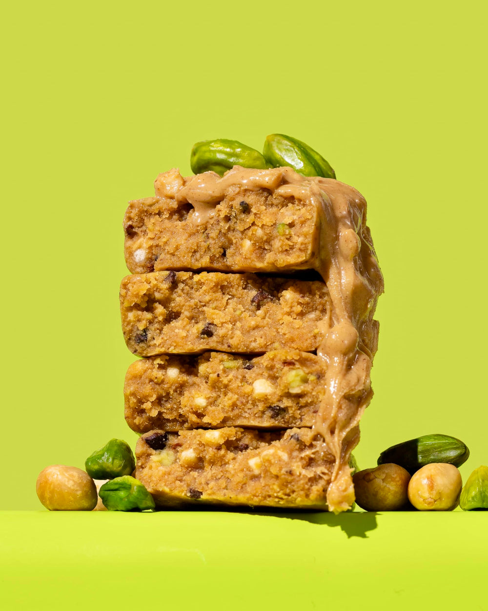 Close-up texture of peanut butter and pistachio crunch, satisfying and clean.