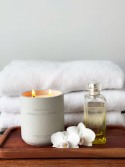 Warm amber glow of WHOLESOME candle in concrete jar during relaxation