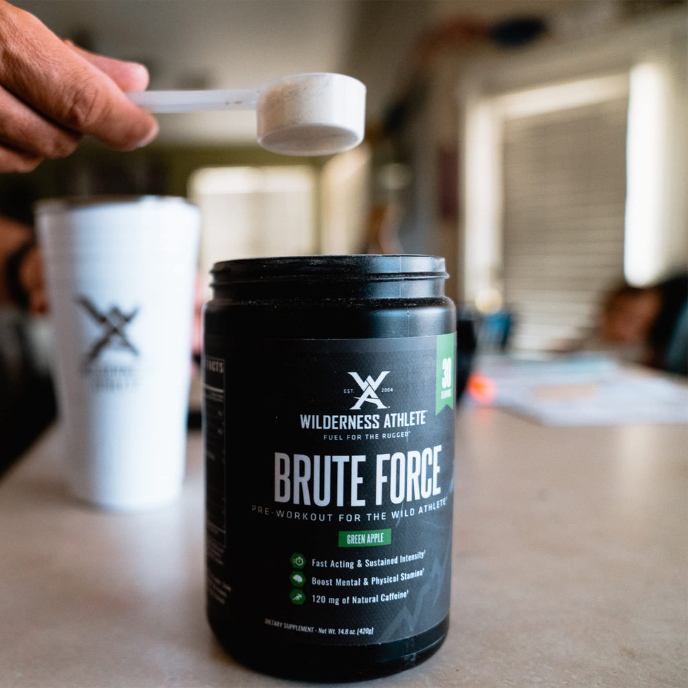 Wilderness Athlete Brute Force pineapple orange flavor bottle close-up for a refreshing energy boost.