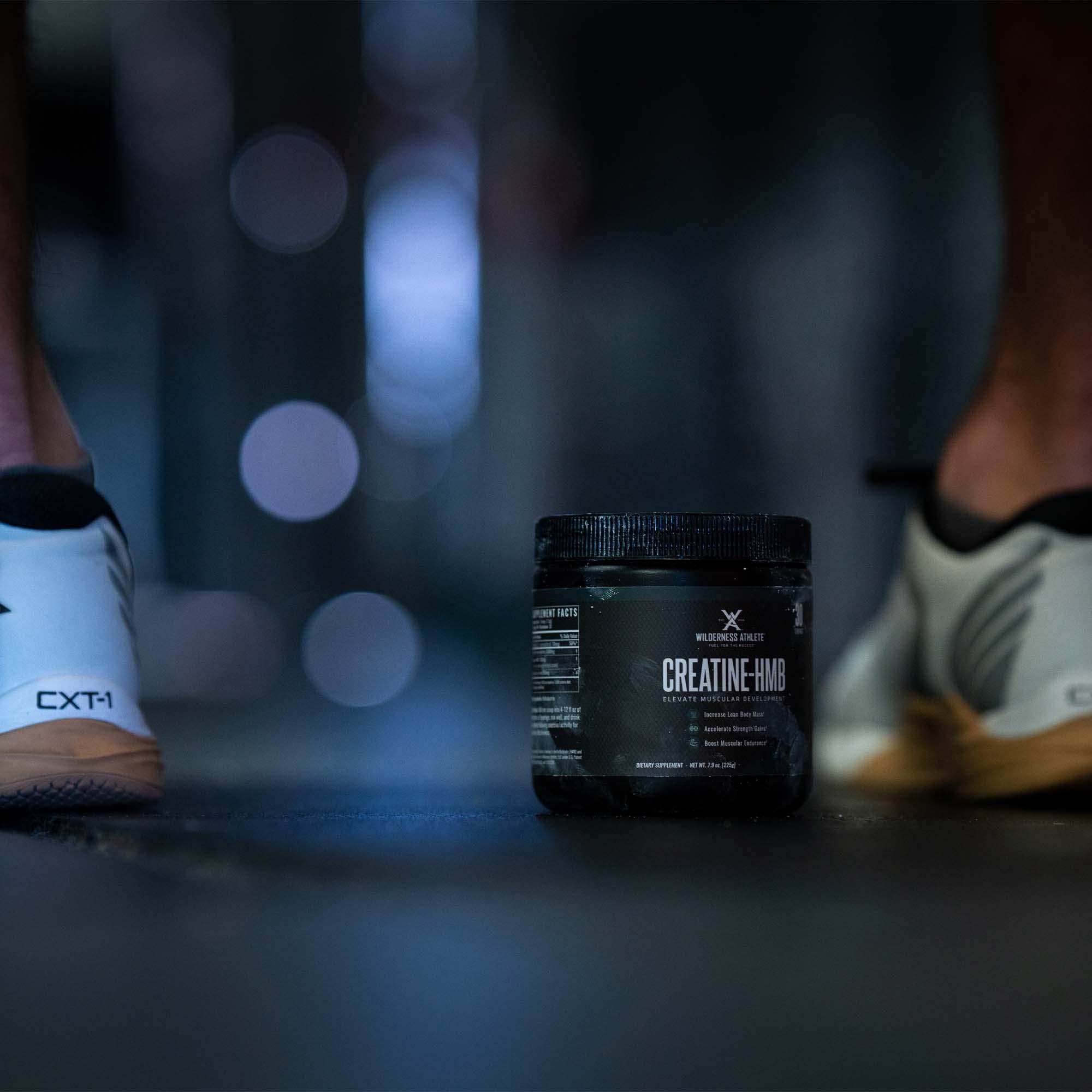 Wilderness Athlete Creatine HMB powder in a glass for mixing and drinking.